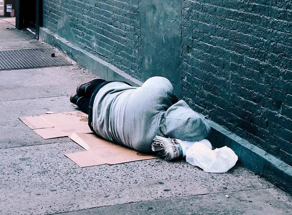 homeless person sleeping on street unsplash